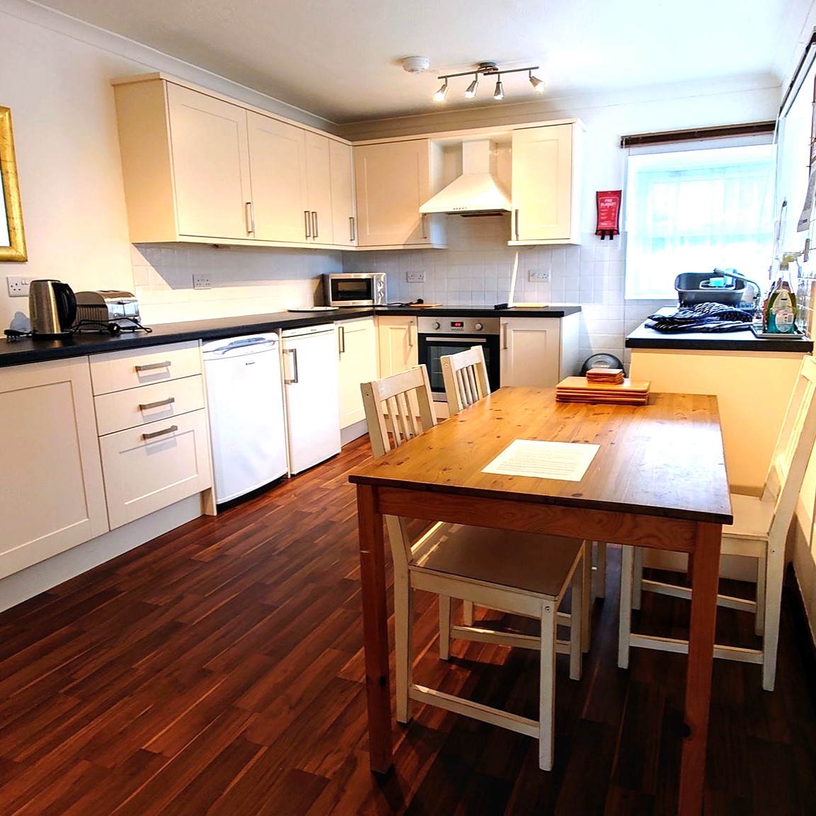 Lebanon Cottage kitchen showing lots of work surfaces and storage, table and chairs and double aspect windows